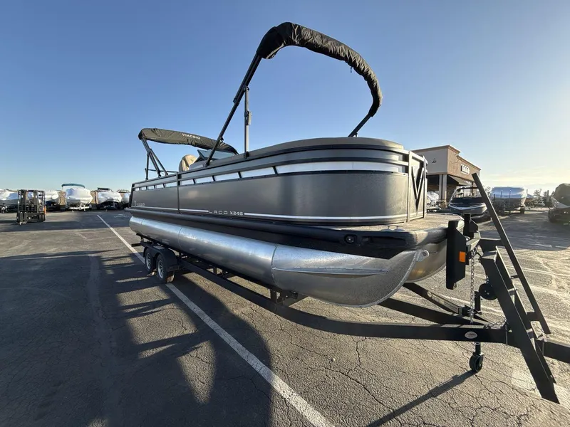 Slide: The Image of 2025 Viaggio x24s pontoon boat on trailer in parking lot, sunny day. - 7