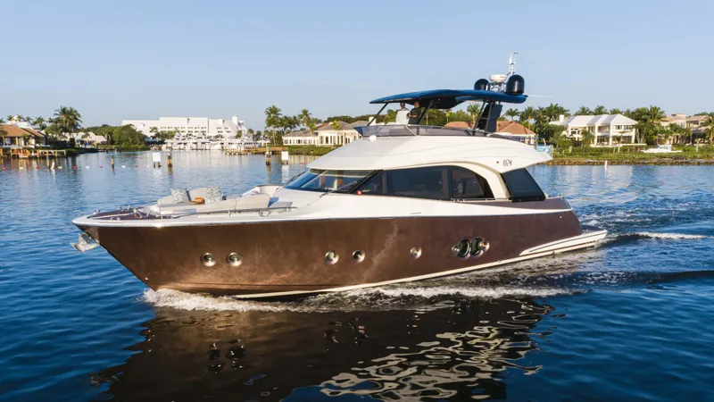 The Image of Luxury 2016 Monte Carlo Yachts MCY 65 cruising on calm waters, surrounded by waterfront homes. - 0