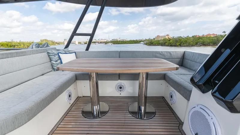 Slide: The Image of Luxurious 2016 Monte Carlo Yachts MCY 65 deck with elegant seating and wooden table. - 18
