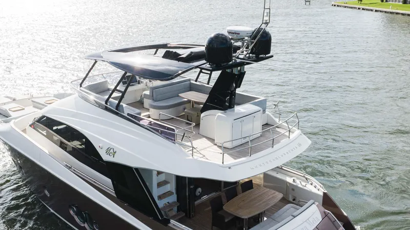 Slide: The Image of 2016 Monte Carlo Yachts MCY 65 luxury yacht on water, featuring spacious deck and modern design. - 3
