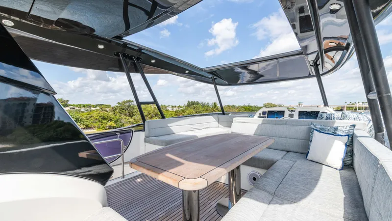 Slide: The Image of Luxurious outdoor seating on 2016 Monte Carlo Yachts MCY 65, featuring elegant cushions and wooden table. - 8