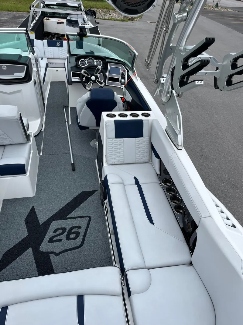 Slide: The Image of 2019 MasterCraft X26 boat interior with plush seating and modern dashboard. - 10