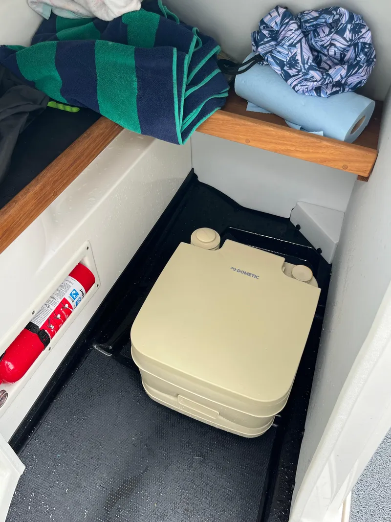 Slide: The Image of 2019 MasterCraft X26 interior with portable toilet, towels, and fire extinguisher. - 11