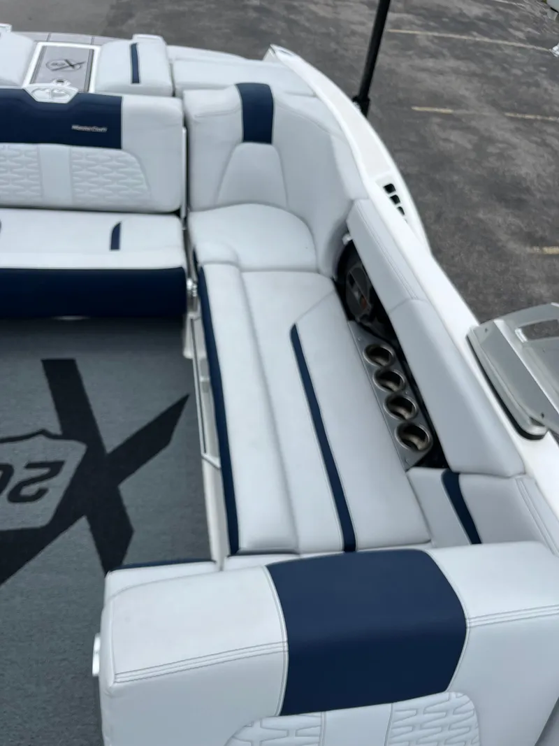 Slide: The Image of 2019 MasterCraft X26 boat interior with white and blue seating and cup holders. - 16