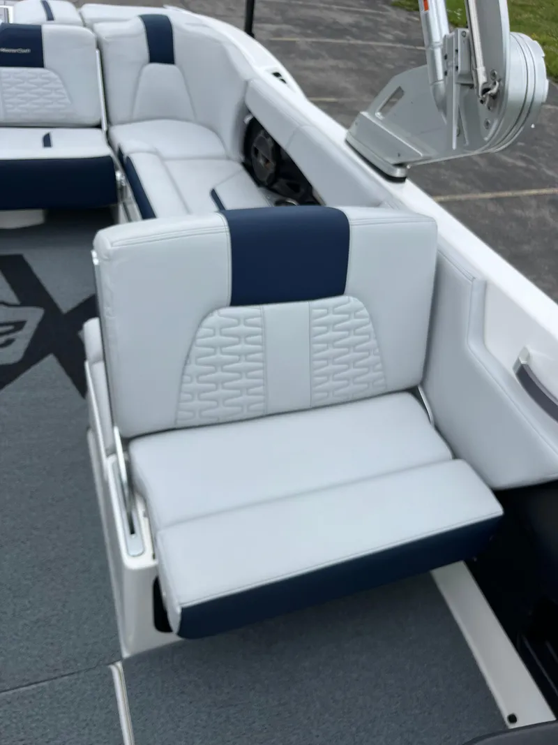 Slide: The Image of 2019 MasterCraft X26 boat interior with white and navy seating. - 18