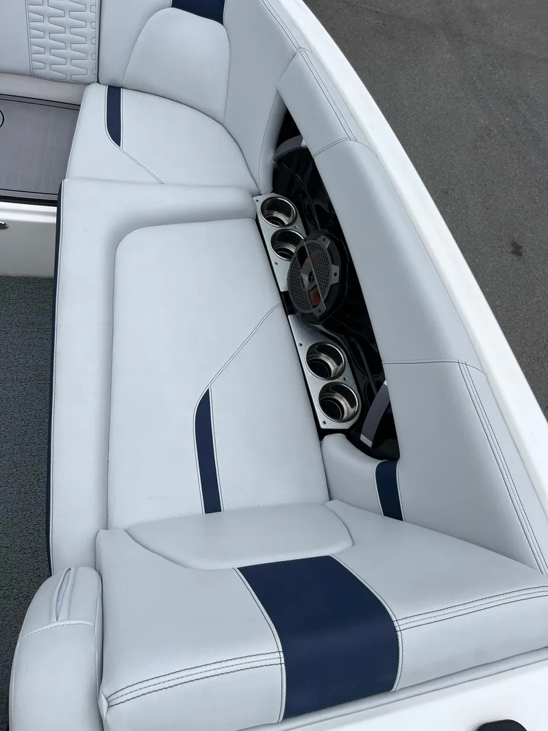 Slide: The Image of 2019 MasterCraft X26 boat interior with white and blue seating and cup holders. - 23