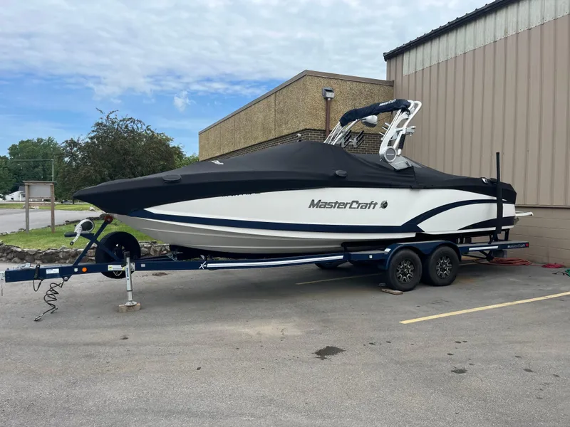 Slide: The Image of 2019 MasterCraft X26 boat on trailer, covered, parked outside a building. - 3