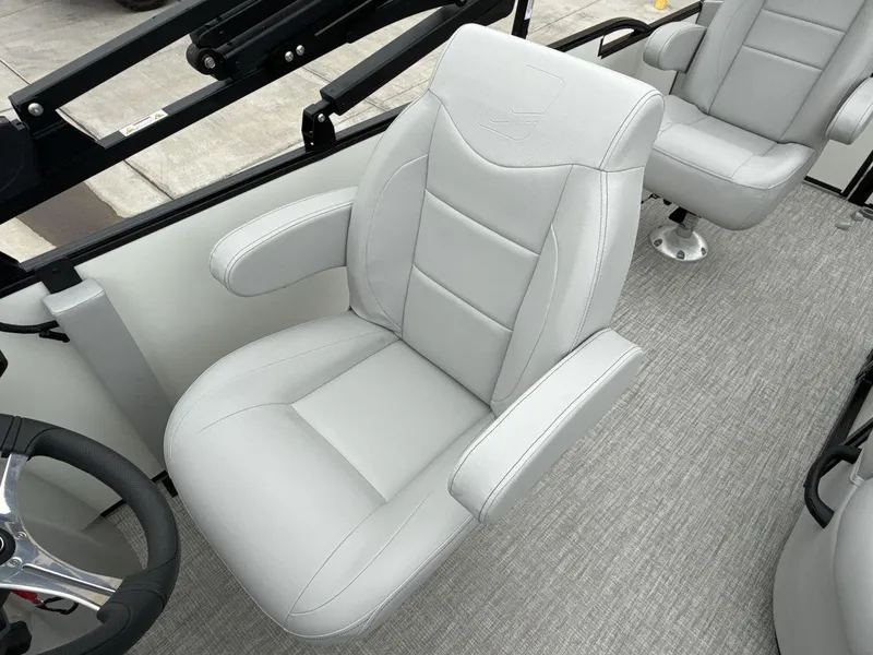 Slide: The Image of 2025 Landau ISLAND BREEZE 23 boat interior with plush white seating and steering wheel. - 13