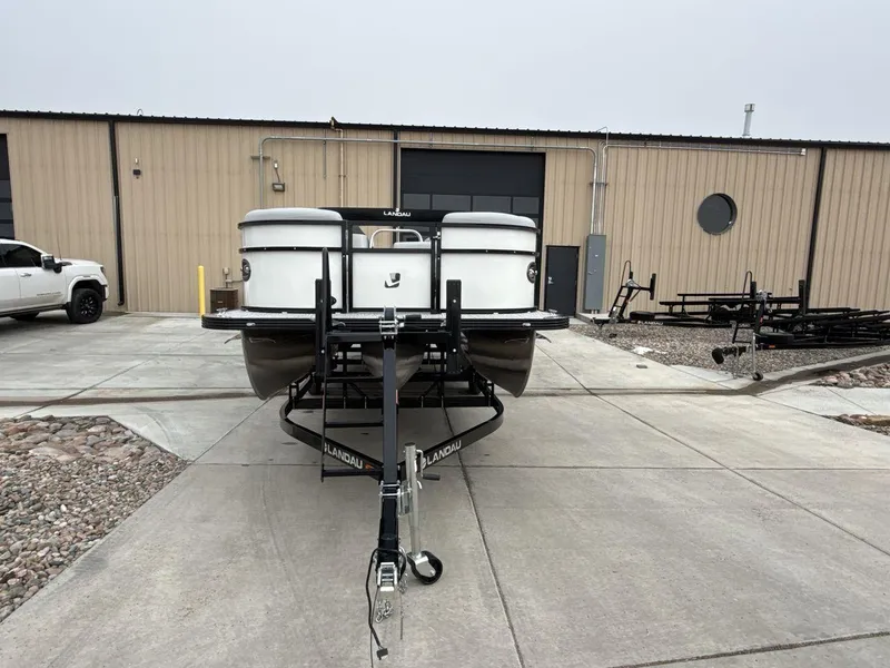 Slide: The Image of 2025 Landau ISLAND BREEZE 23 pontoon boat on trailer outside warehouse. - 8