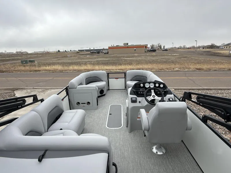 Slide: The Image of 2025 Landau ISLAND BREEZE 23 pontoon boat interior with gray seating and steering console. - 9