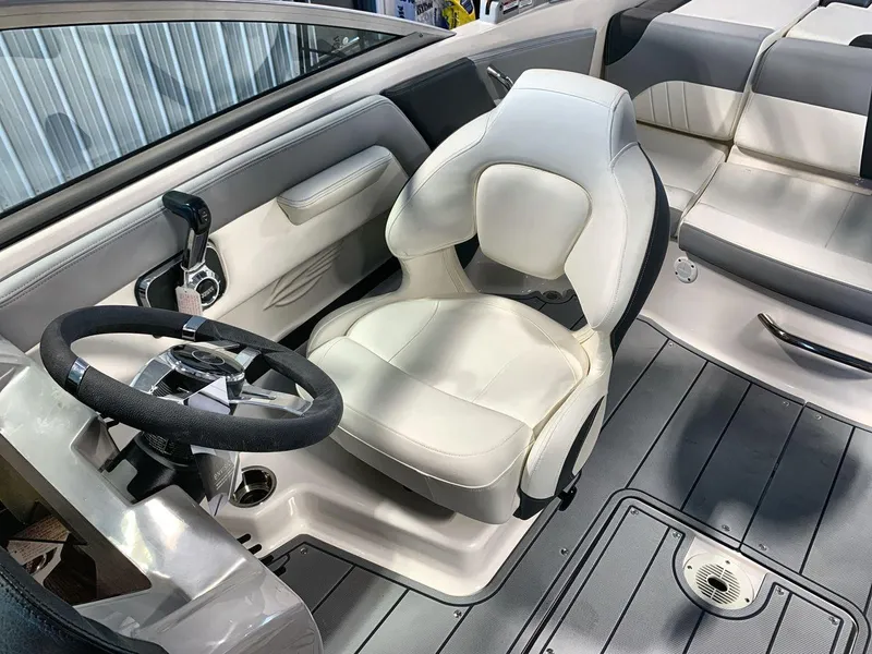 Slide: The Image of 2025 Chaparral 21 SSi boat interior with steering wheel and white captain's chair. - 13