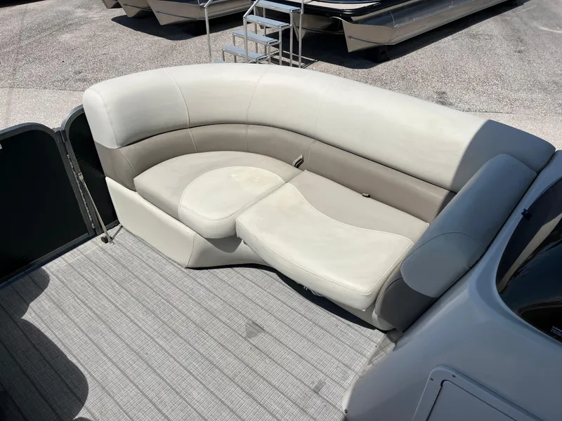 Slide: The Image of 2020 Manitou 20 Aurora LE Standard boat with beige seating and gray flooring. - 13