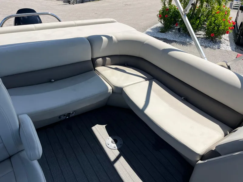 Slide: The Image of 2020 Manitou 20 Aurora LE Standard boat interior with beige seating and gray flooring. - 16