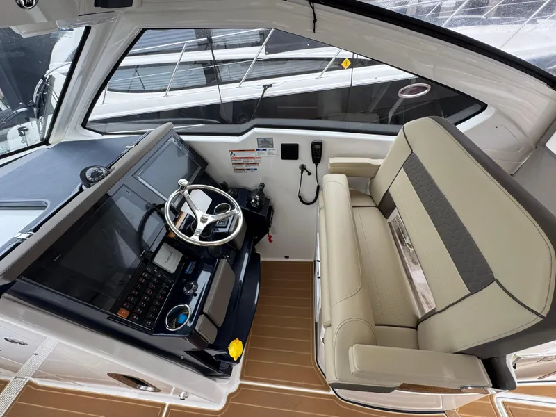 Slide: The Image of 2019 Pursuit DC 365 Dual Console boat interior with steering wheel and seating area. - 14