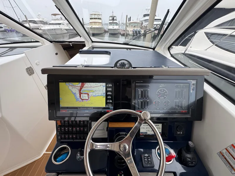 Slide: The Image of 2019 Pursuit DC 365 Dual Console helm with navigation screens and steering wheel. - 19