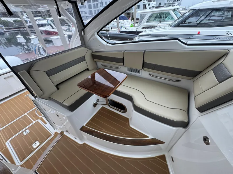 Slide: The Image of 2019 Pursuit DC 365 Dual Console interior with beige seating and wooden table. - 23