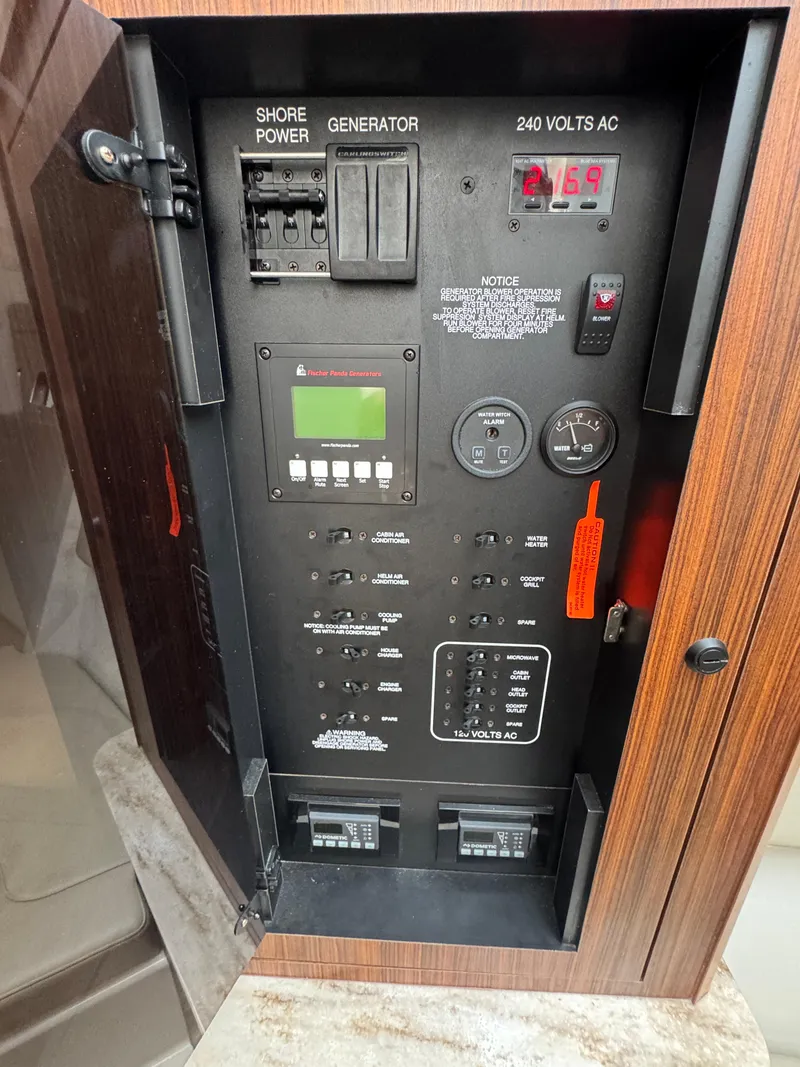 Slide: The Image of Electrical panel of 2019 Pursuit DC 365 Dual Console boat, showing shore power and generator controls. - 27