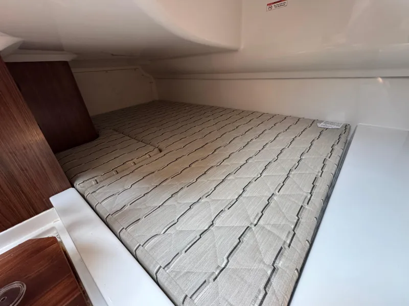 Slide: The Image of 2019 Pursuit DC 365 Dual Console cabin interior with cushioned sleeping area. - 30