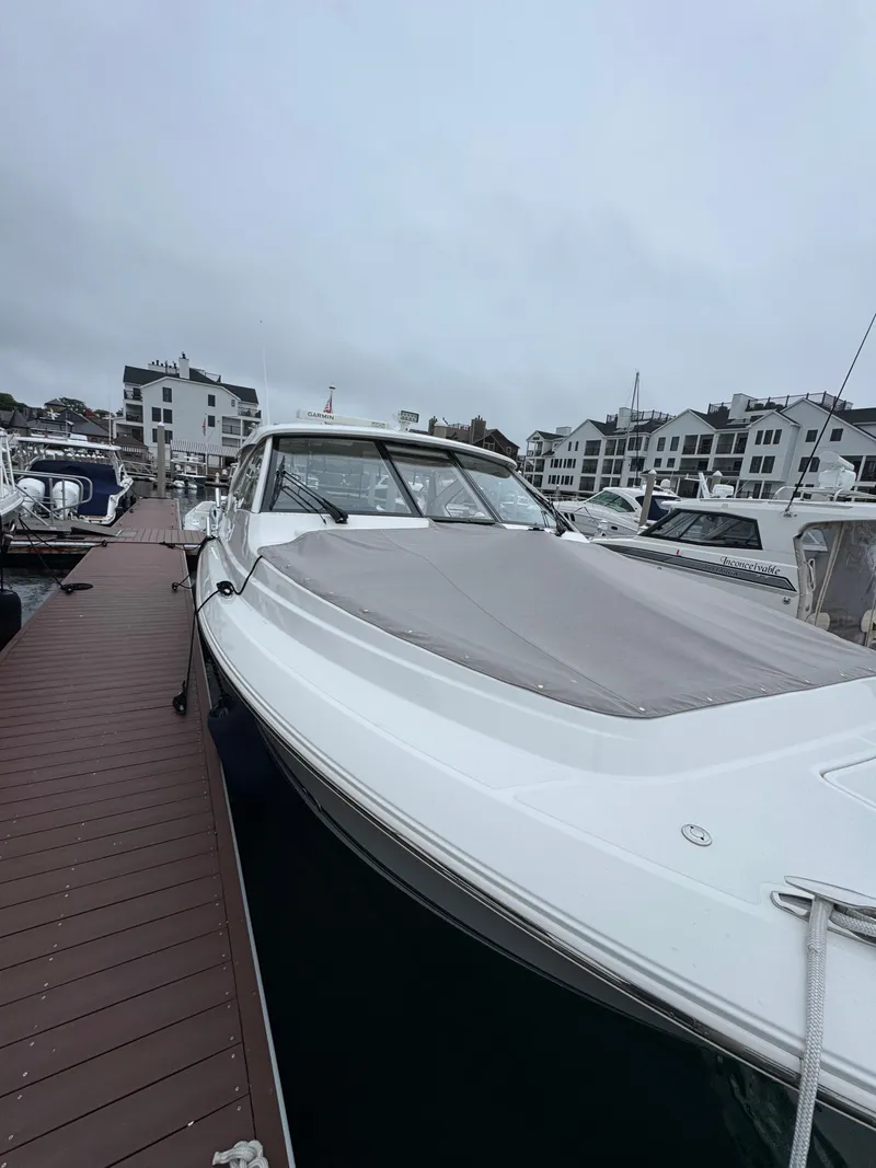 Slide: The Image of 2019 Pursuit DC 365 Dual Console boat docked at marina on a cloudy day. - 35