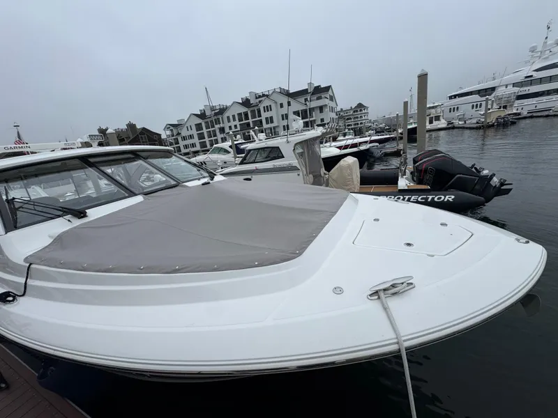 Slide: The Image of 2019 Pursuit DC 365 Dual Console boat docked in a marina, overcast sky. - 5
