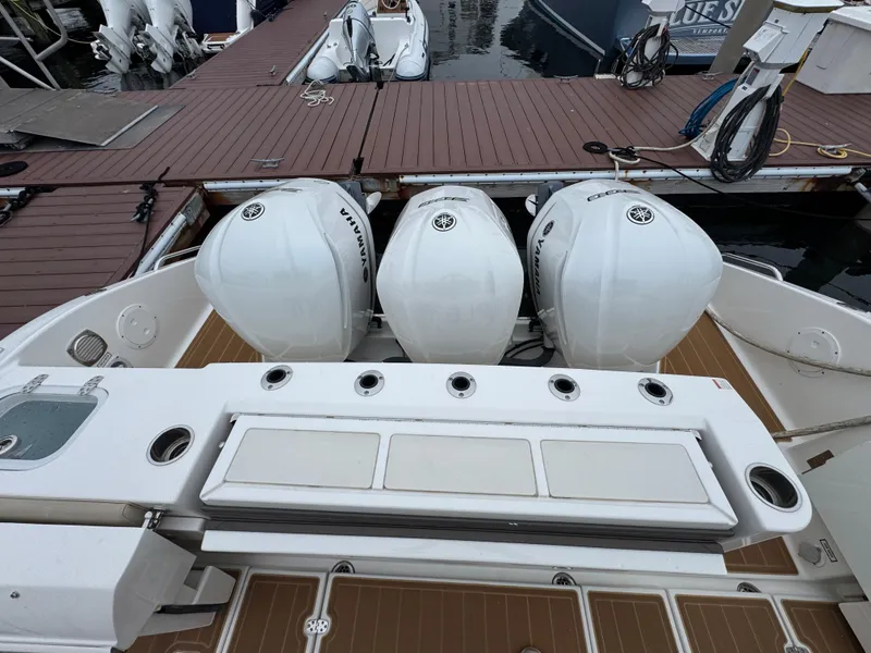Slide: The Image of 2019 Pursuit DC 365 Dual Console with triple Yamaha outboard engines at dock. - 8