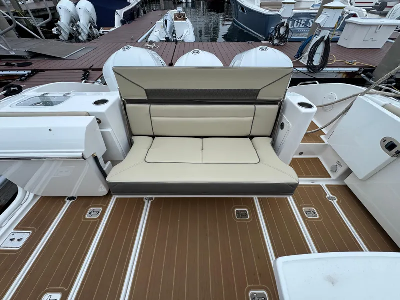 Slide: The Image of 2019 Pursuit DC 365 Dual Console boat with beige seating and teak-style flooring. - 9
