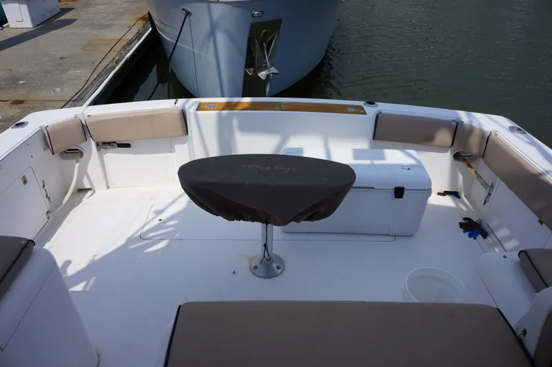 Slide: The Image of 1997 Bertram 36 Moppie boat interior with cushioned seating and covered table. - 11