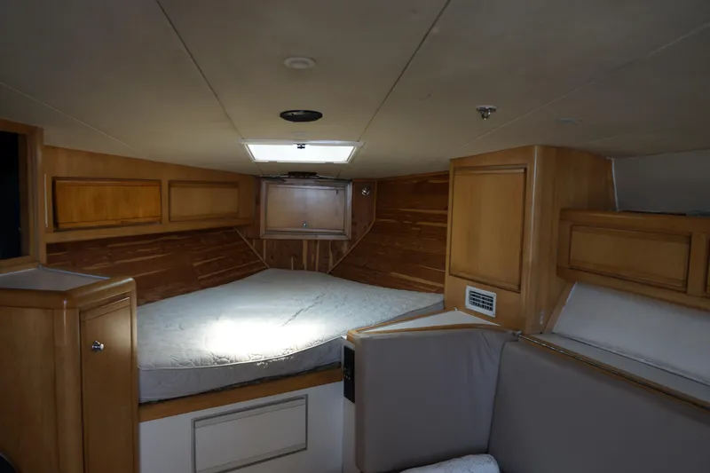 Slide: The Image of 1997 Bertram 36 Moppie cabin interior with wood paneling and bed. - 13