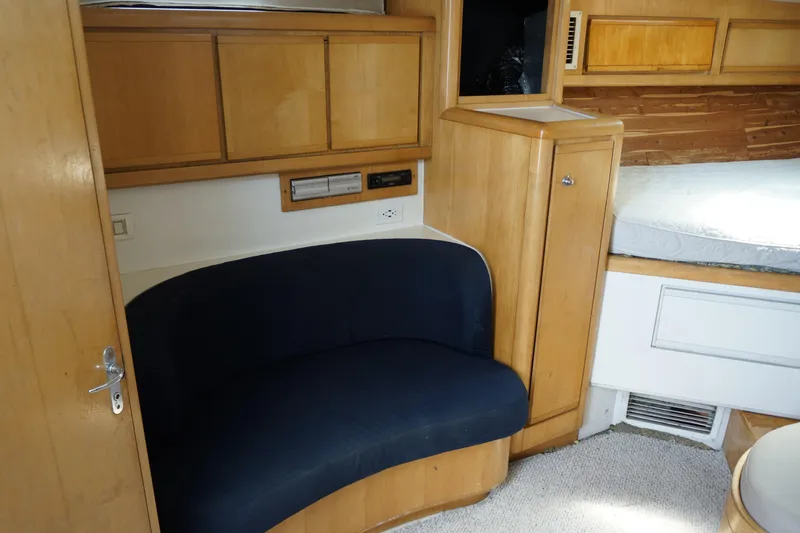 Slide: The Image of Interior of 1997 Bertram 36 Moppie yacht with wooden cabinetry and blue seating. - 14