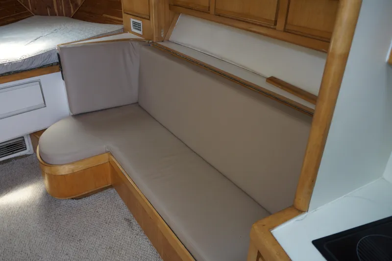 Slide: The Image of Interior of 1997 Bertram 36 Moppie yacht with beige seating and wooden accents. - 15
