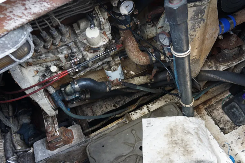Slide: The Image of Engine compartment of a 1997 Bertram 36 Moppie boat, showing mechanical components and hoses. - 18