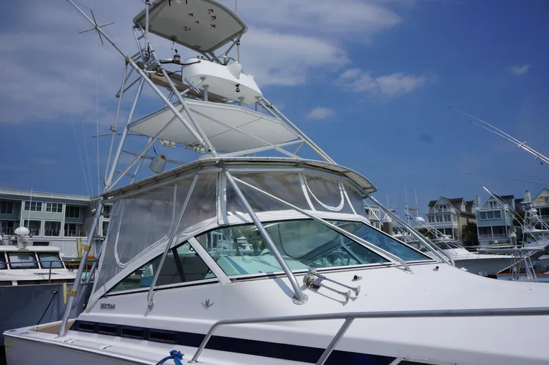 Slide: The Image of 1997 Bertram 36 Moppie yacht with tower, docked under blue sky. - 3