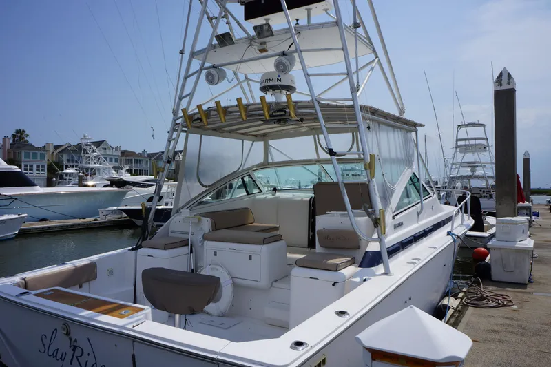 Slide: The Image of 1997 Bertram 36 Moppie yacht docked at marina, featuring spacious deck and fishing equipment. - 4