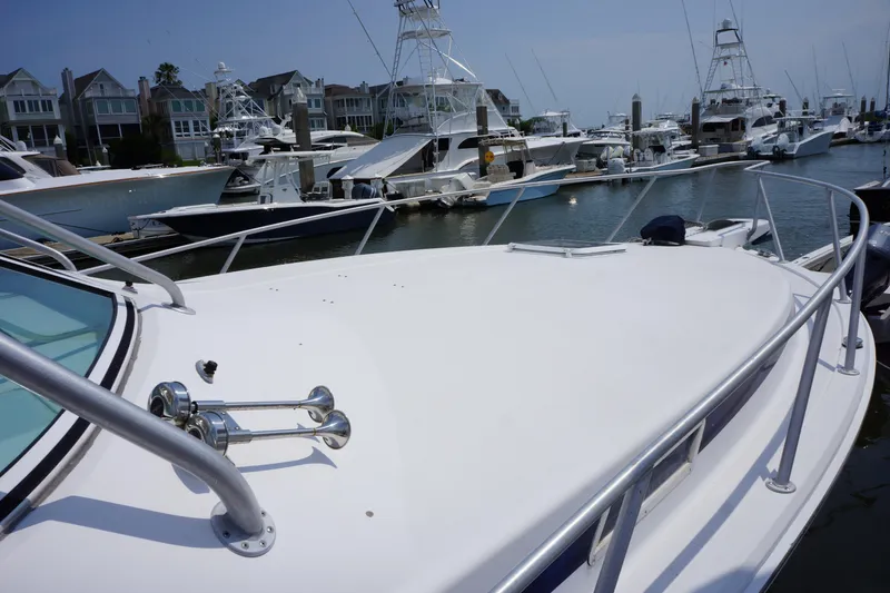 Slide: The Image of Bertram 36 Moppie 1997 yacht docked in marina, surrounded by other boats and waterfront homes. - 6
