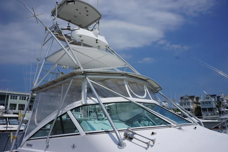 Slide: The Image of 1997 Bertram 36 Moppie yacht with tower, docked under a clear blue sky. - 7