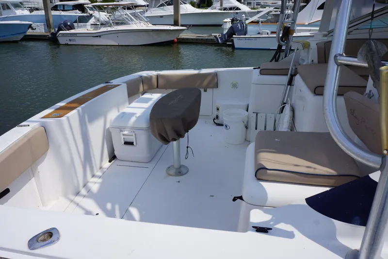 Slide: The Image of 1997 Bertram 36 Moppie boat interior with seating and fishing equipment at a marina. - 8