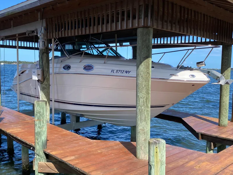 The Image of 2008 Sea Ray 270 Amberjack boat docked on a lift over water. - 0