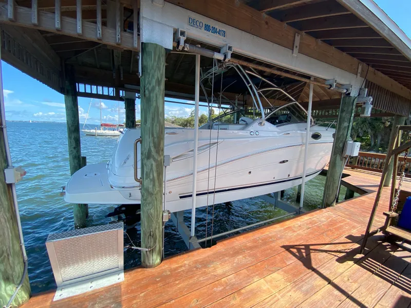 Slide: The Image of 2008 Sea Ray 270 Amberjack boat docked in a wooden boathouse over water. - 1