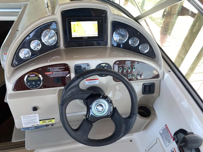 Slide: The Image of 2008 Sea Ray 270 Amberjack dashboard with steering wheel and navigation controls. - 10