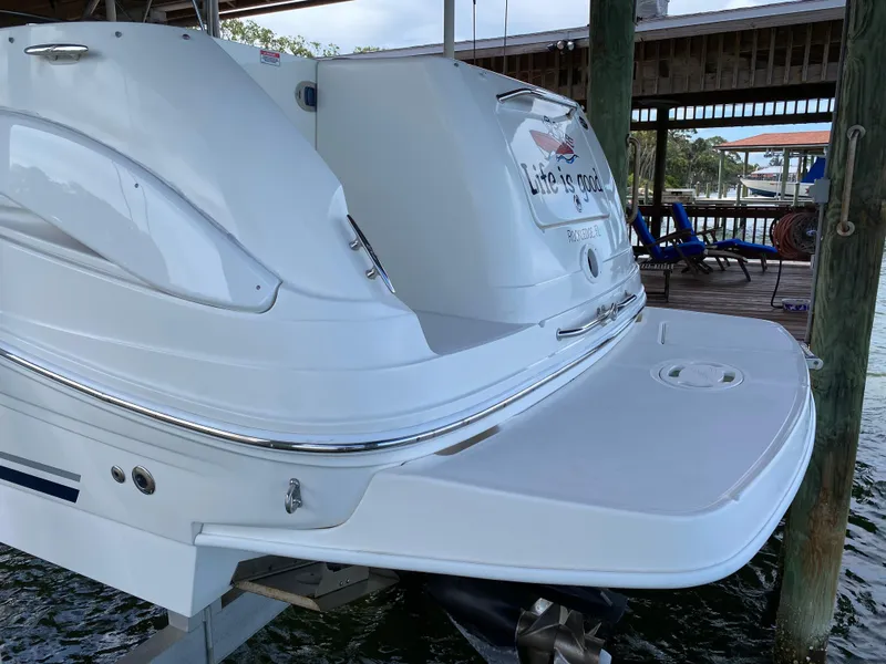 Slide: The Image of 2008 Sea Ray 270 Amberjack boat docked, featuring a sleek white exterior and swim platform. - 3