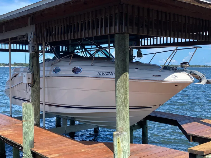 Slide: The Image of 2008 Sea Ray 270 Amberjack boat docked on a lift over water. - 34