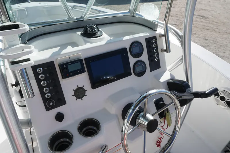 Slide: The Image of 2012 Robalo R200 Center Console boat dashboard with steering wheel and navigation controls. - 33