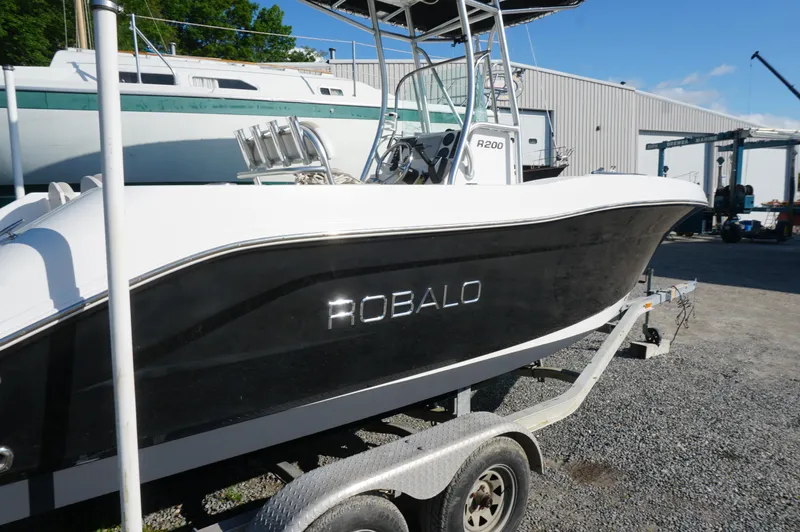 Slide: The Image of 2012 Robalo R200 Center Console boat on trailer, parked outdoors. - 40