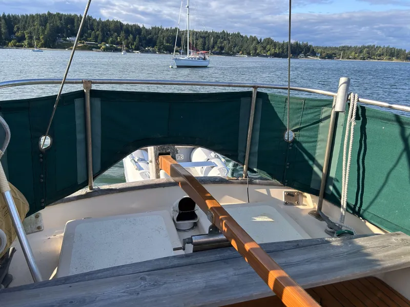 Slide: The Image of 1979 Cape George 36 sailboat cockpit with green canvas, scenic lake view. - 1