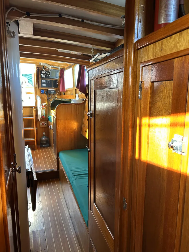 Slide: The Image of Interior of a 1979 Cape George 36 sailboat with wooden furnishings and green seating. - 13