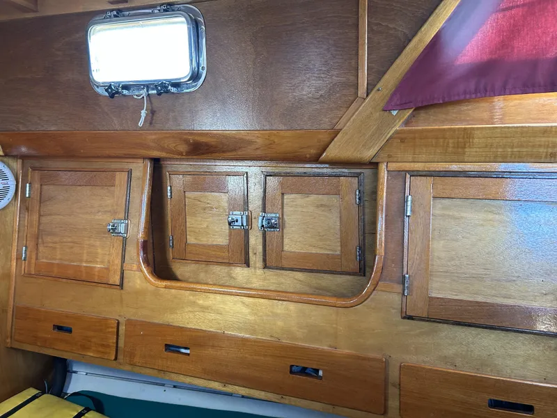 Slide: The Image of Wooden interior cabinets and porthole in a 1979 Cape George 36 sailboat. - 18