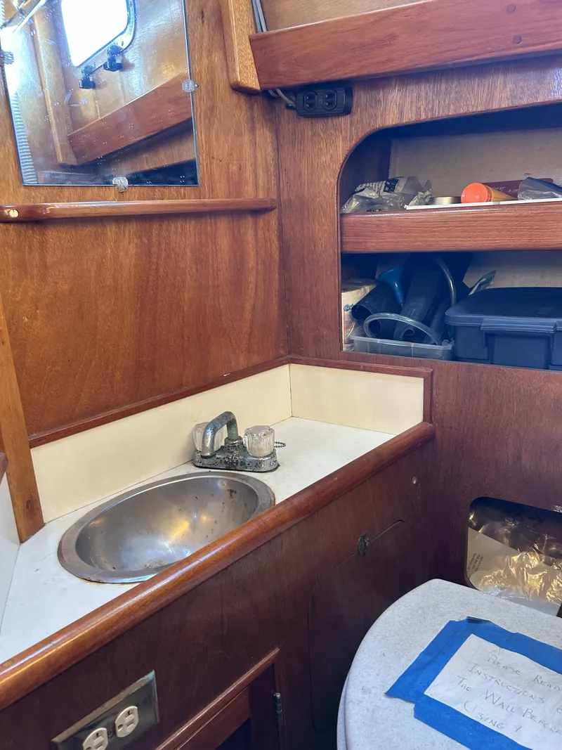 Slide: The Image of 1979 Cape George 36 boat interior with wooden cabinetry and compact sink area. - 20