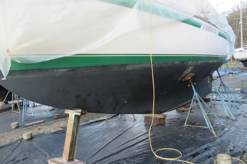 Slide: The Image of 1979 Cape George 36 sailboat on stands, undergoing maintenance with protective covering. - 29