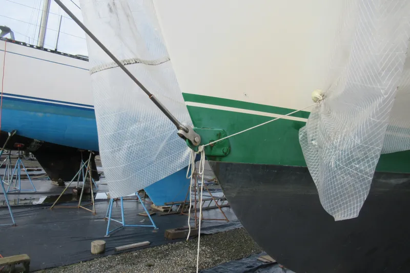Slide: The Image of Cape George 36 sailboat from 1979, partially covered, on stands in a boatyard. - 32