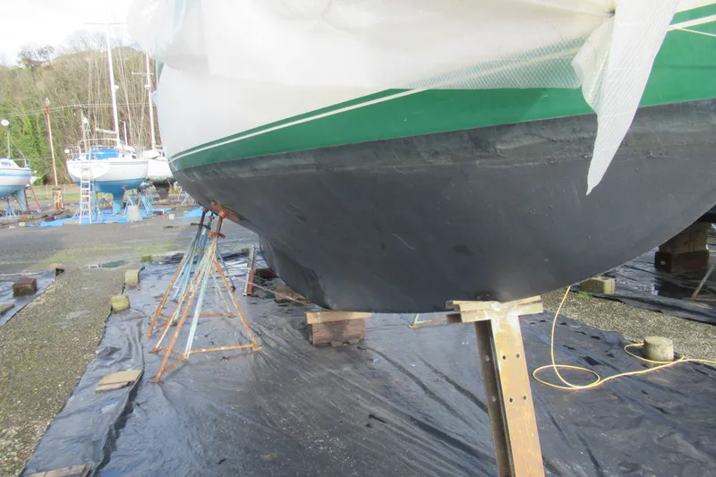 Slide: The Image of 1979 Cape George 36 sailboat on stands, undergoing maintenance in a boatyard. - 41